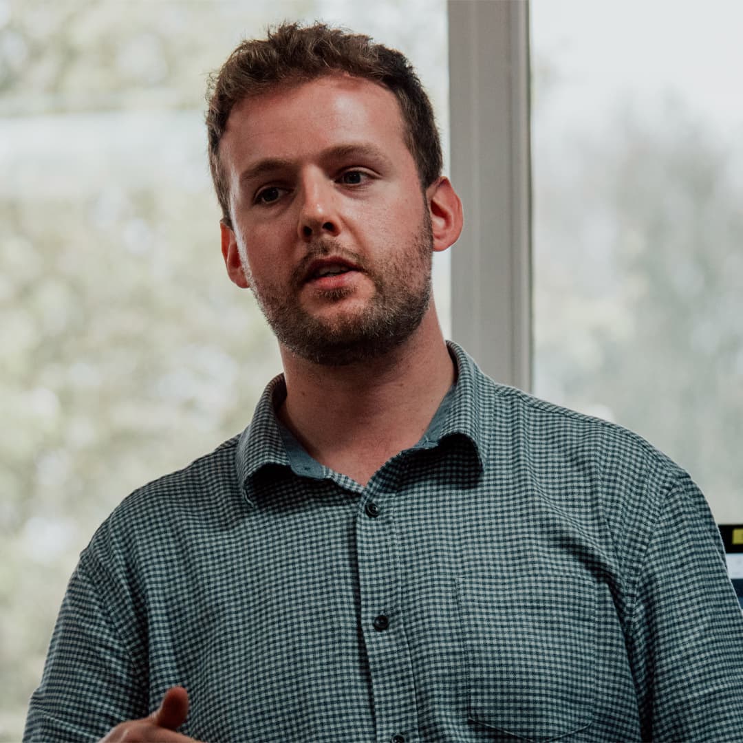 Nigel Fryatt dressed in a white checked shirt standing in front of blurred windows